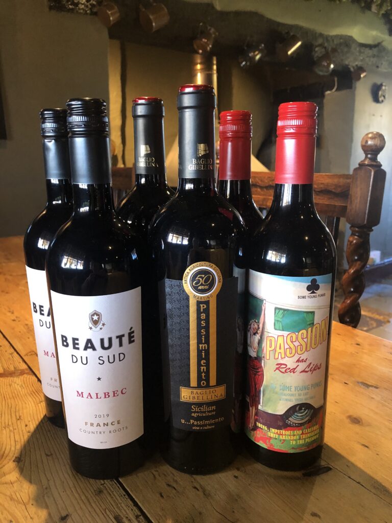 Selection of wine bottles displayed on the wooden bar at The Butchers Arms.