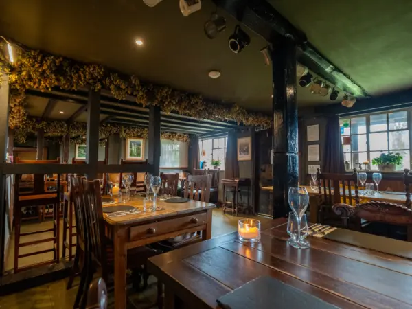 Candlelit dining room at The Butchers Arms, Eldersfield, with hop-garlanded beams